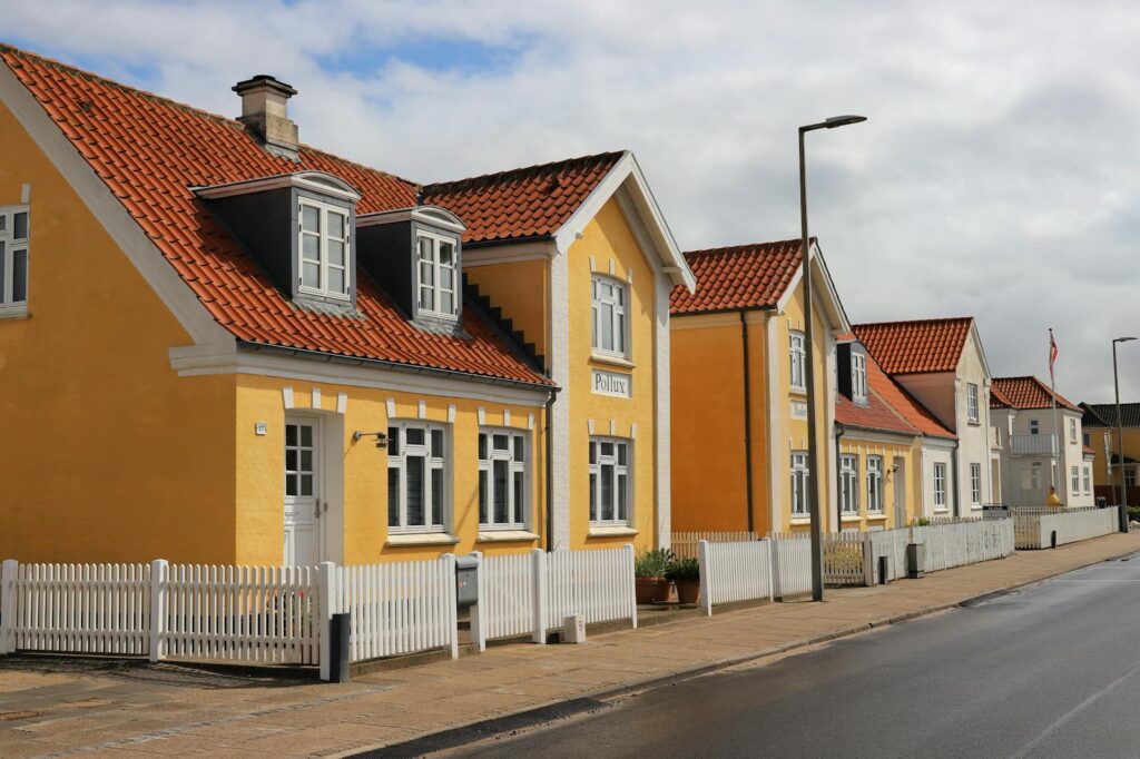 Picturesque yellow houses with red roofs in Løkken, Denmark, showcasing Scandinavian architecture.